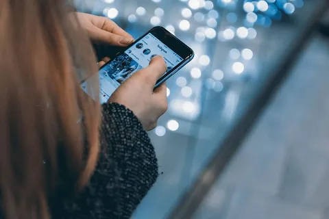 年轻女孩使用智能手机和Instagram应用程序