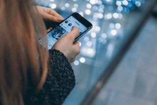 年轻女孩使用智能手机和Instagram应用程序