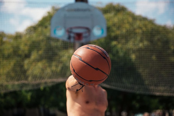 一个年轻的白人男子在篮球场上右手拿着一个篮球