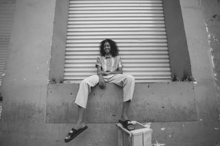 穿着白色长裤和黑色Nike Benassi滑梯的女士