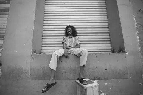 穿着白色长裤和黑色Nike Benassi滑梯的女士 穿着白色长裤和黑色Nike Benassi滑梯的女士