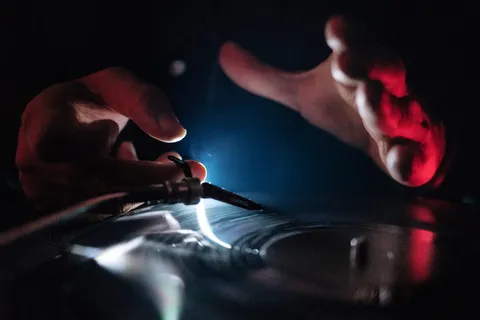 DJ和乙烯基唱片的手 DJ和乙烯基唱片的手