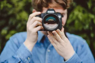 手持数码单反相机的人