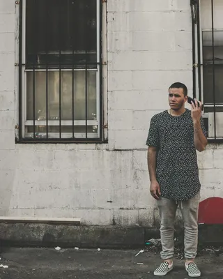 白天，一名男子手持电话站在大楼前