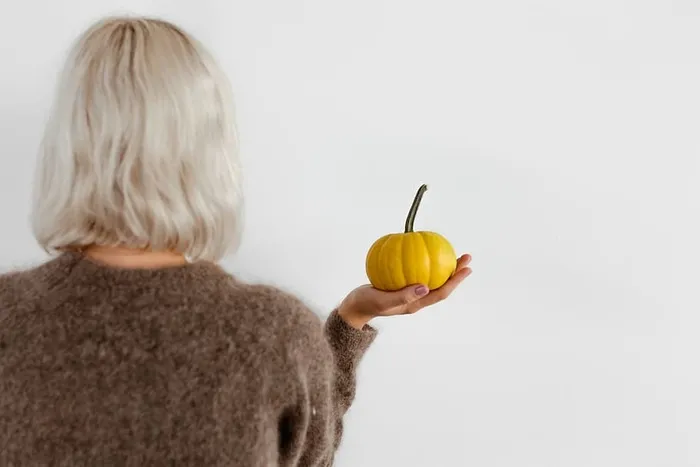 穿毛衣的女人手里拿着南瓜 穿毛衣的女人手里拿着南瓜