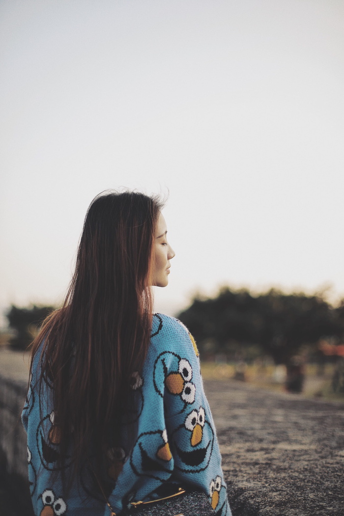 身着蓝色夹克、闭着眼睛的女子的后视图照片