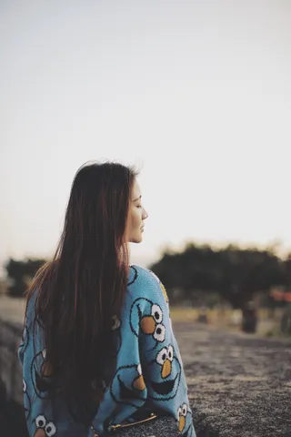 身着蓝色夹克、闭着眼睛的女子的后视图照片