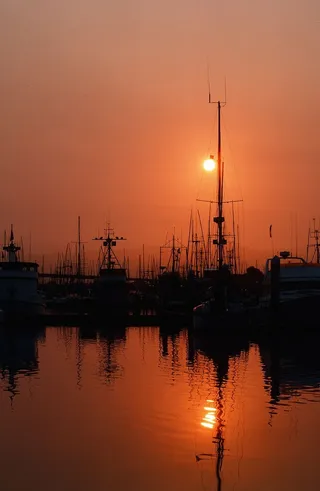 日落时，渔船被拴在码头上，背景是大海