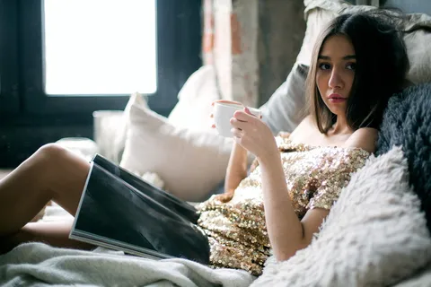 身穿亮片米色露肩连衣裙的女子躺在床上 身穿亮片米色露肩连衣裙的女子躺在床上