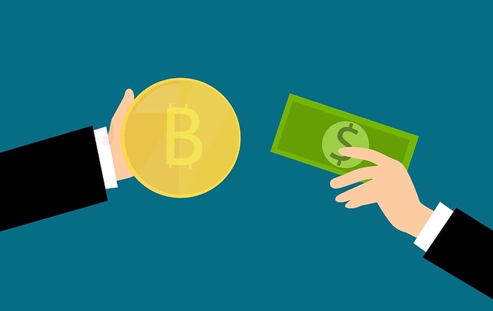 用比特币加密货币兑换普通现金的手的图示。