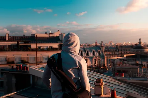 站在大楼上穿着灰色套头衫连帽衫的人 站在大楼上穿着灰色套头衫连帽衫的人