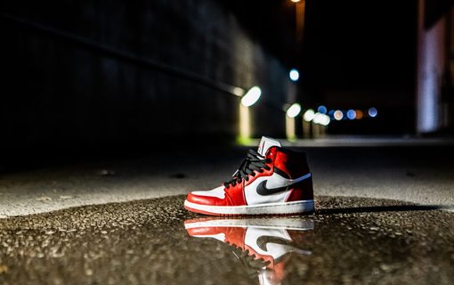红白相间的Air Jordan 1运动鞋，水泥地面