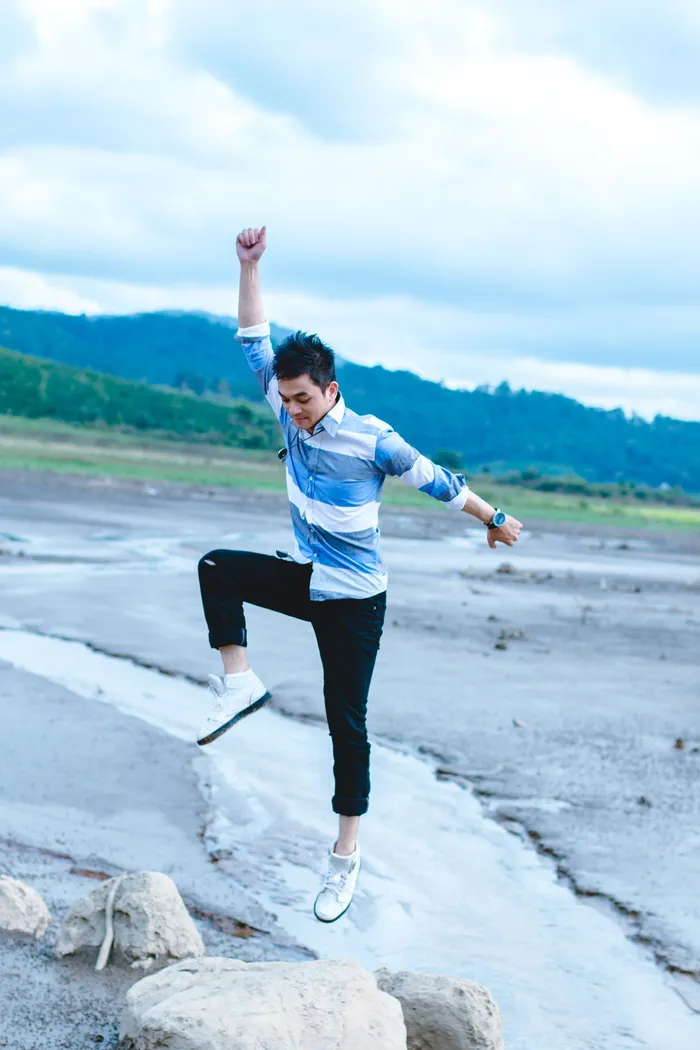 男子在灰色岩层上跳跃