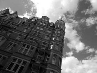 多云天空下建筑物的灰度照片