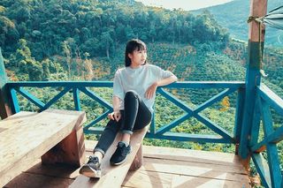 坐在棕色木凳上的女人