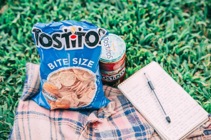 Tostito包在罐头和笔记本旁边 Tostito包在罐头和笔记本旁边