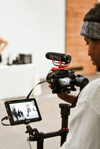 站在监视器旁边的人