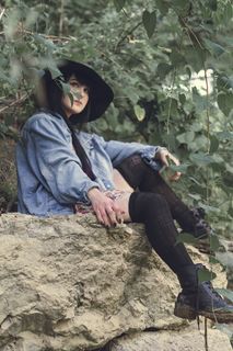 坐在棕色岩石上的女人