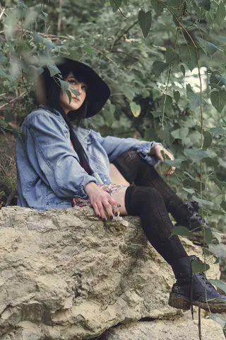 坐在棕色岩石上的女人