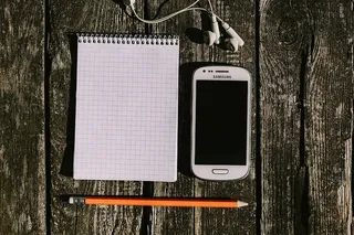 木质背景上有各种物品的白色智能手机