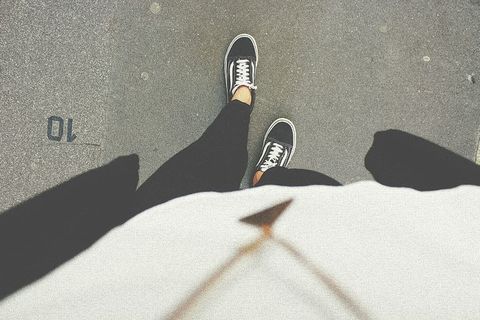 一个人低头看着他的脚和鞋子