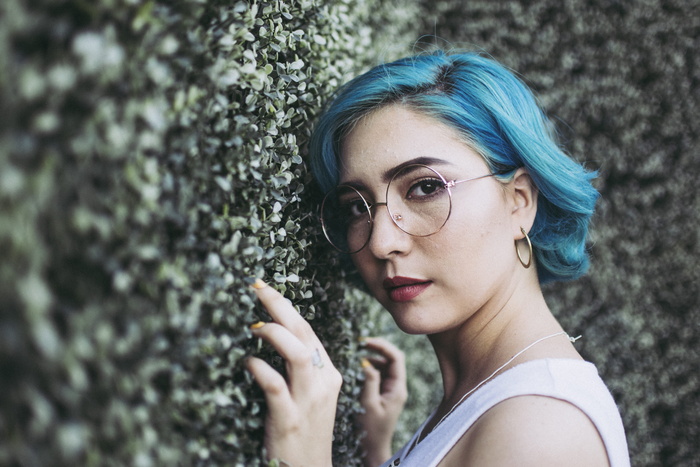 一名女子靠在灌木丛上的特写照片