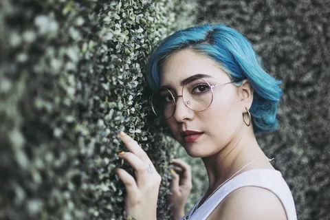 一名女子靠在灌木丛上的特写照片