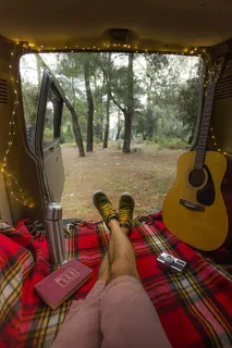 坐在车内靠近棕色原声吉他的人