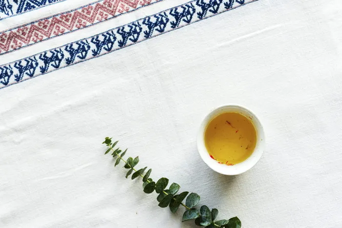 白色餐桌垫上酱汁旁的绿叶植物