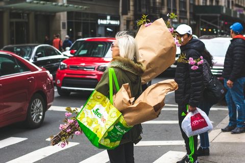 举着一束鲜花的女人站在路边