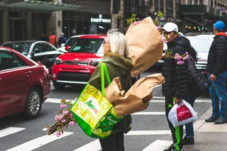 举着一束鲜花的女人站在路边