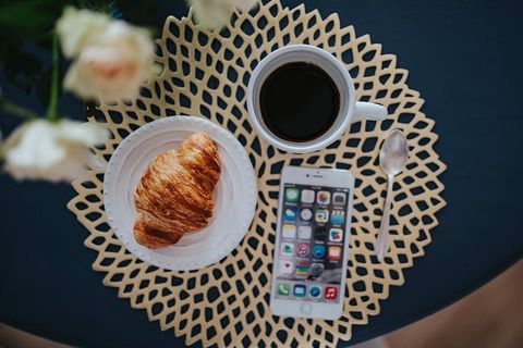 带白色花朵和金色咖啡垫的圆形早餐桌