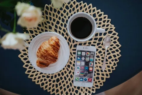 带白色花朵和金色咖啡垫的圆形早餐桌