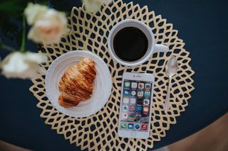 带白色花朵和金色咖啡垫的圆形早餐桌