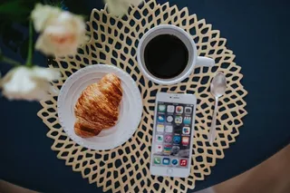 带白色花朵和金色咖啡垫的圆形早餐桌