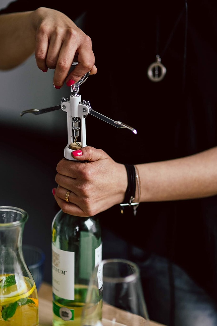 双手用开瓶器打开酒瓶