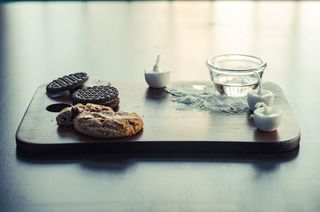 棕色木板上的三支白色茶点蜡烛