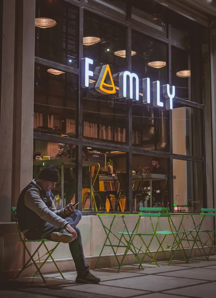 坐在椅子上的男子在户外使用小工具