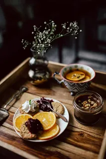 酒店早餐的客房服务托盘:饼干、果酱、巧克力慕斯、橘子水果、茶 酒店早餐的客房服务托盘:饼干、果酱、巧克力慕斯、橘子水果、茶