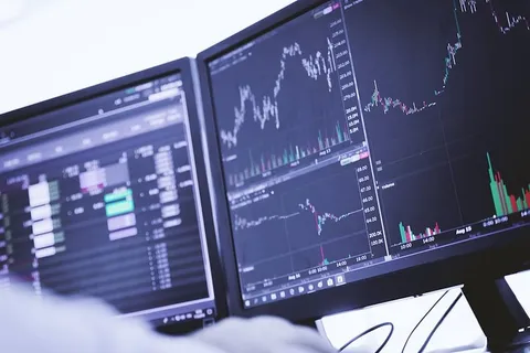 交易员在电脑上工作，显示器上有图表