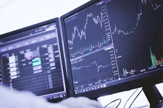 交易员在电脑上工作，显示器上有图表