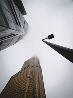 白天灰色天空下城市建筑物附近的路灯