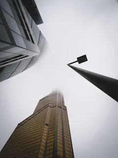 白天灰色天空下城市建筑物附近的路灯