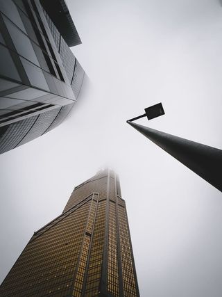 白天灰色天空下城市建筑物附近的路灯