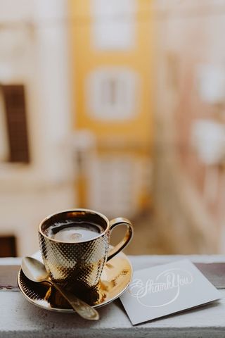 在窗前的金杯里喝咖啡