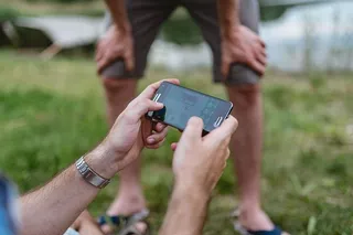 男子手在手机上玩电子游戏的特写镜头