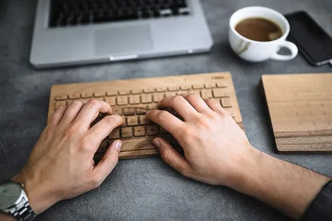 在木制键盘上打字的年轻人