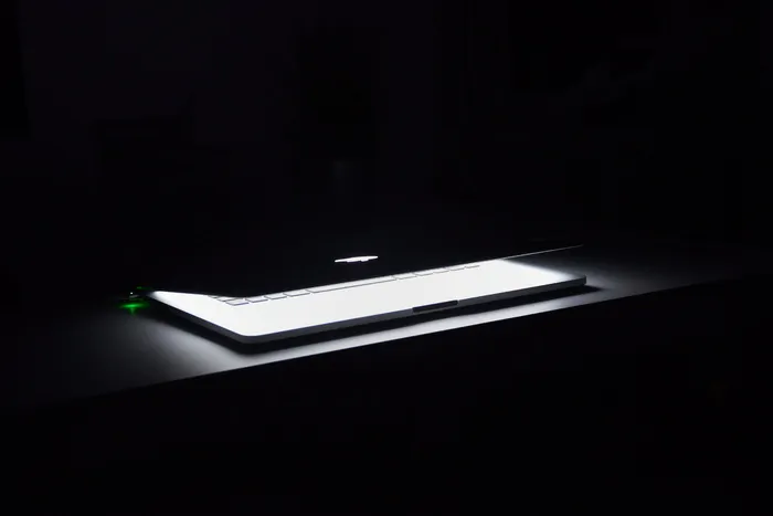 Macbook在白色木质表面上半开的照片