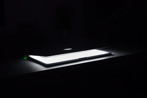Macbook在白色木质表面上半开的照片 Macbook在白色木质表面上半开的照片