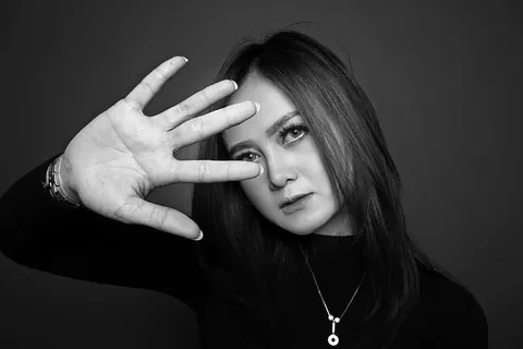 女人举手的灰度照片